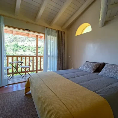 Dormitorio amplio y agradable, con cama doble grande, estufa de pellets para los dias más frios, dos butacas, perchero, cuarto de baño completo, escritorio, y un balcón con vistas hermosas. Esta habitación es la parte de la vivienda que no es cueva.