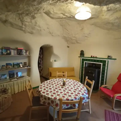 El cuarto de estar, comedor y al mismo tiempo la entrada de la Cueva. Aquí estarás muy a gusto, igual in invierno como en verano. La forma de las paredes desiguales y la altura del techo transforman este lugar en un sitio de paz y tranquilidad.